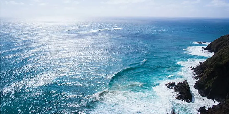 Expanse of blue sea with rugged cliffs to the right